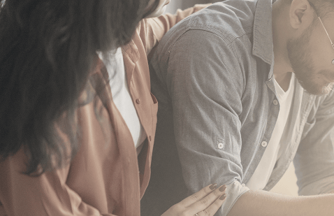 Close-up of a woman comforting a man with a gentle touch on his arm, symbolizing emotional support, empathy, and partnership during health challenges