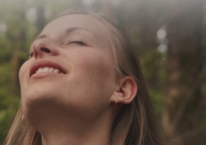 Close-up of a smiling woman with eyes closed, symbolizing relief and the joy of regained well-being